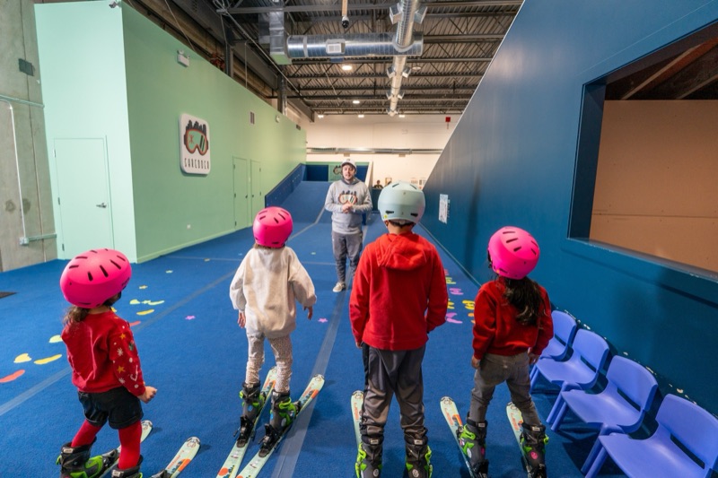 Small group of kids in ski gear with instructor at Shredder